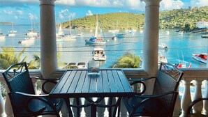 A covered outdoor seating area with a view of a marina filled with boats. - Grande Bay Resort - Mojo Blue Luxury Studio Beachfront! (Cruz Bay)