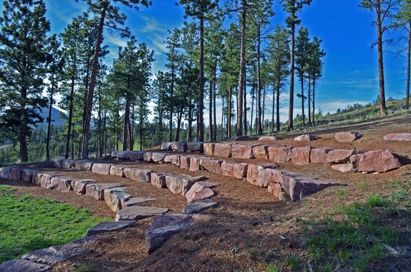 A natural landscape with a stone pathway and tall pine trees. - Majestic Lodge only 22 miles from the base of Pike's Peak (Woodland Park)