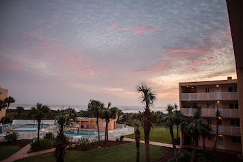 Beautiful sunset casts its rays on sky outside our window! Note view and pools!
