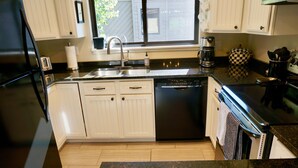 A kitchen with white cabinets, a black dishwasher, a sink, and a window with blinds. - 3 BR/BA End Unit, Lg Decks, Views (Sun Valley)