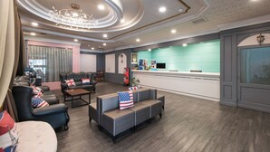 A hotel lobby with a reception desk, seating area, and a chandelier. - Back Home Hotel (Chiayi City)