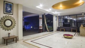 Un'ampia hall con pavimento in marmo, una panca, uno specchio decorativo e un'ampia finestra che offre vista all'esterno.