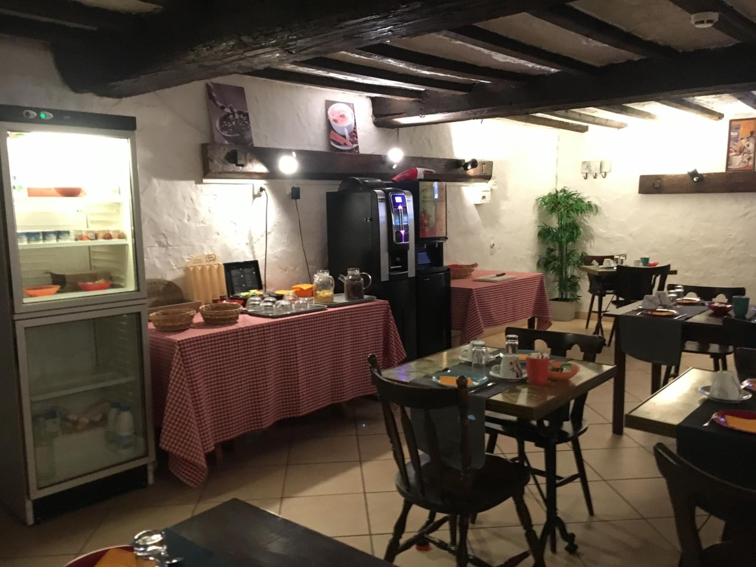 Un restaurante con mantel a cuadros, un refrigerador y una cafetera.