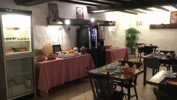 Un restaurante con mantel a cuadros, un refrigerador y una cafetera.