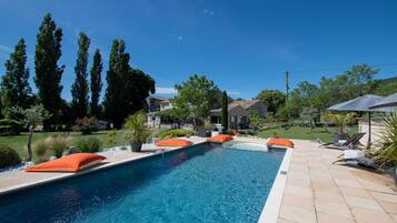 Een seizoensgebonden buitenzwembad en parasols bij het zwembad