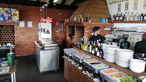 Een restaurant met een bakstenen muur, een Coca-Cola bord en diverse drank- en etensautomaat.