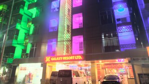 A multi-story building with illuminated signage for "Galaxy Resort Ltd." and "Tamarind Kitchen." - Galaxy Resort Limited (Cox's Bazar)