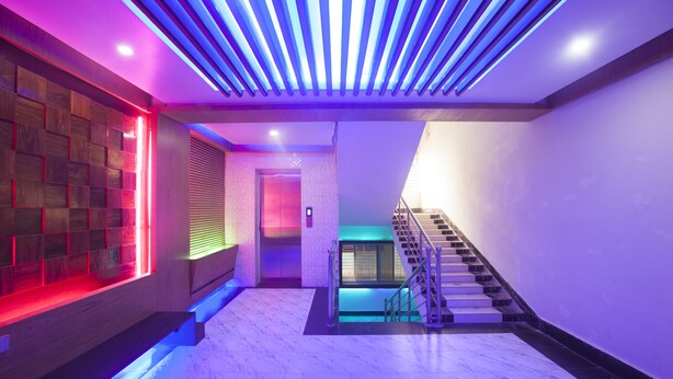 A modern interior with a staircase, a reception area, and a wall with a unique lighting design. - Galaxy Resort Limited (Cox's Bazar)
