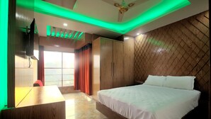 A modern bedroom with a large bed, wooden wardrobe, and a desk. - Galaxy Resort Limited (Cox's Bazar)