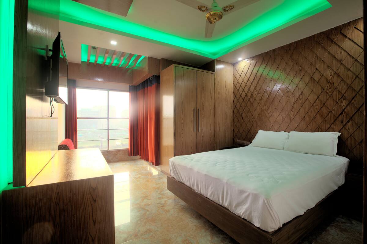 Ein modernes Schlafzimmer mit einem großen Bett, einem Holfischschrank und einem Schreibtisch.