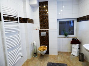 A bathroom with a toilet, a radiator, a sink, and a window. - Relaxen im alten Winzerhaus Fewo EG (Rech)