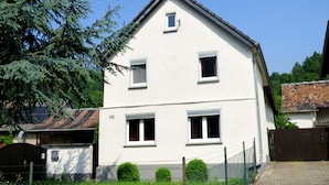 A two-story house with a white exterior, a small window on the second floor, and a visible number '125' on the side. - Relaxen im gemütlichen Eifelhaus (Kesseling)