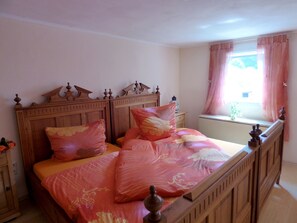 A bedroom with a wooden four-poster bed, floral bedding, and a window with curtains. - Relaxen im gemütlichen Eifelhaus (Kesseling)
