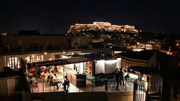 A rooftop bar with a view of the Acropolis at night. - Mosaikon - Hostel (Athens)