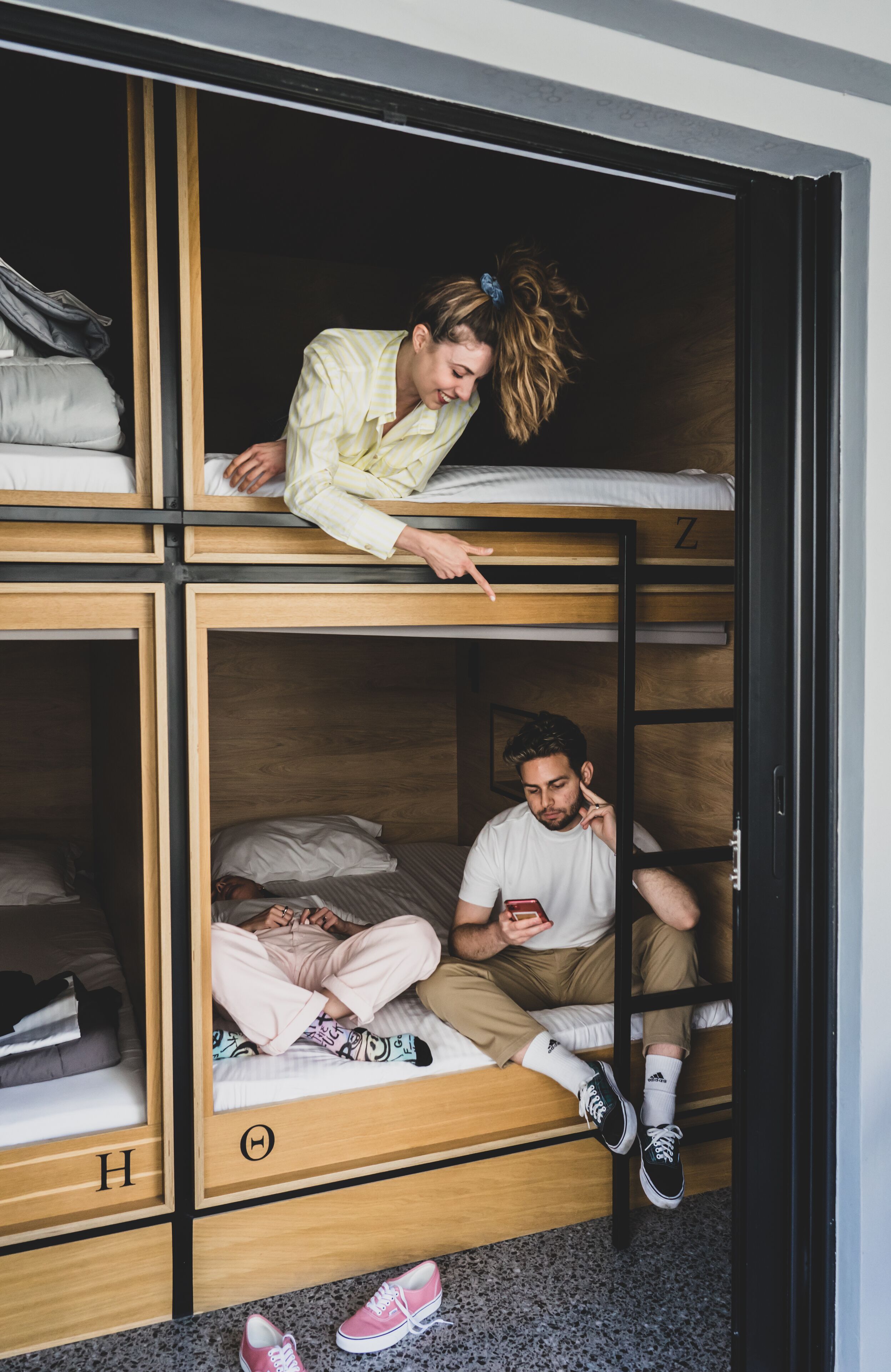 Une chambre avec un lit superposé à deux niveaux, chaque niveau étant doté d’un cadre en bois et d’un matelas.
