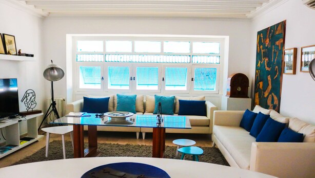 A modern living room with a sofa, coffee table, and a dining table.