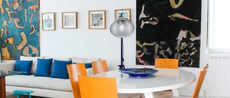 Uma área de refeições com uma mesa redonda, cadeiras e um tapete no chão.
