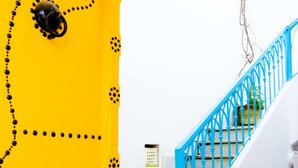 A staircase with blue railings and a yellow wall with decorative patterns.