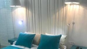 Un dormitorio con cama, dos mesitas de noche y una lámpara de pared.