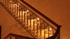 A staircase with ornate metal railings and a wooden handrail.