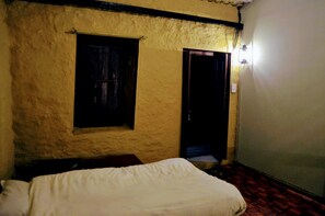 A room with a bed, a window, and a door. - Retreat at Damaar (Dhunkharka)