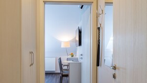 A narrow hallway with wooden flooring leading to a small kitchenette area. - Penzion Longus (Kyjov)