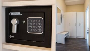 Een veilige opslagruimte met een combinatiecijferslot en keypad, een bankje, en witte kasten in een modern interieur.