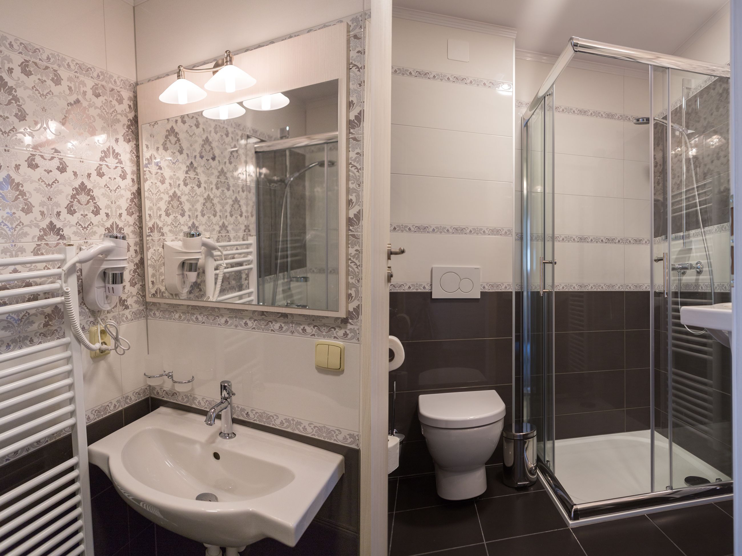 Een badkamer met een wastafel, toilet en douchecabine.