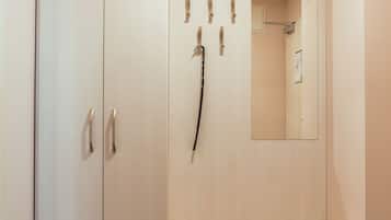 A room with a wardrobe, a mirror, and a bench.