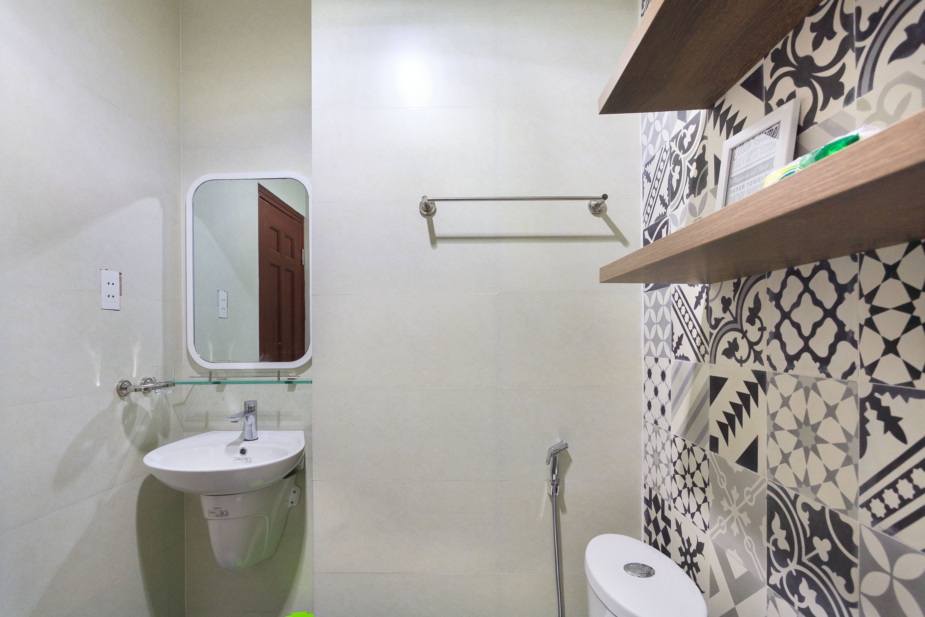 A bathroom with a sink, mirror, and toilet.