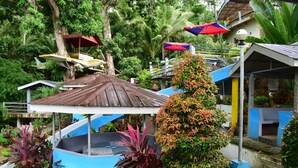 A tropical resort with a swimming pool, covered seating areas, and lush vegetation. - Villa d' Arco Resort (Santa Cruz)
