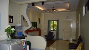 A modern kitchen with a curved island, a refrigerator, and a dining area with chairs. - Villa d' Arco Resort (Santa Cruz)
