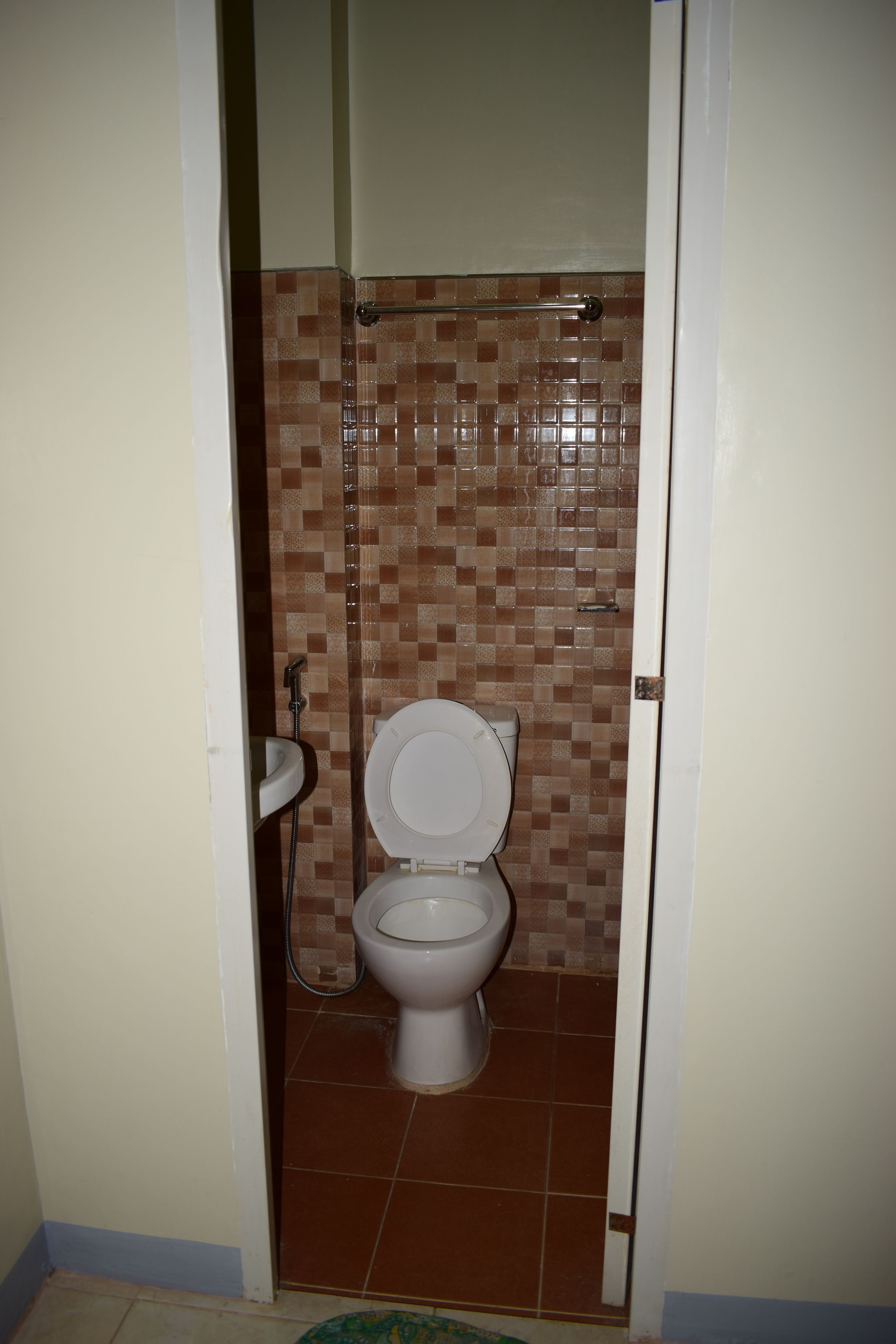 A small bathroom with a toilet, a sink, and a shower.