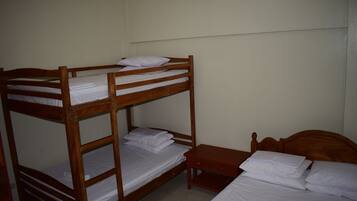 A bunk bed room with a wooden headboard, a wooden nightstand, and a single bed.