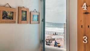 Una habitación con vista a la playa, puertas numeradas y cuadros en la pared.