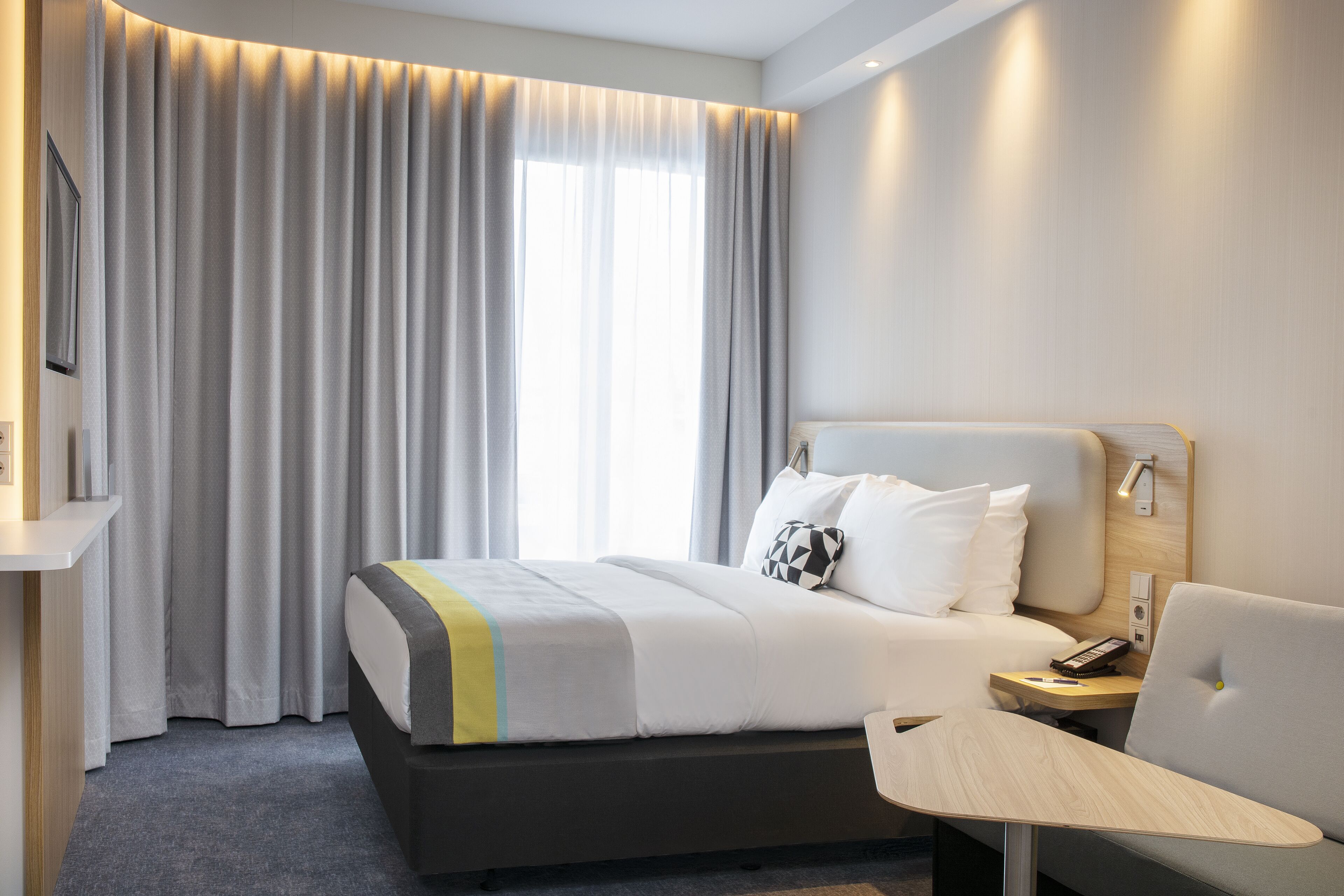 Une chambre d’hôtel avec un lit, une table de chevet et un téléviseur.