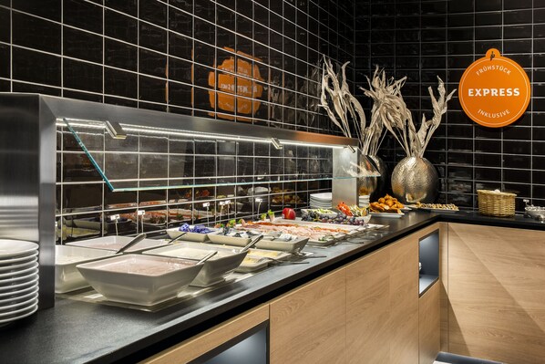 Un buffet proposant une variété de plats et une vitrine réfrigérée pour les présenter.
