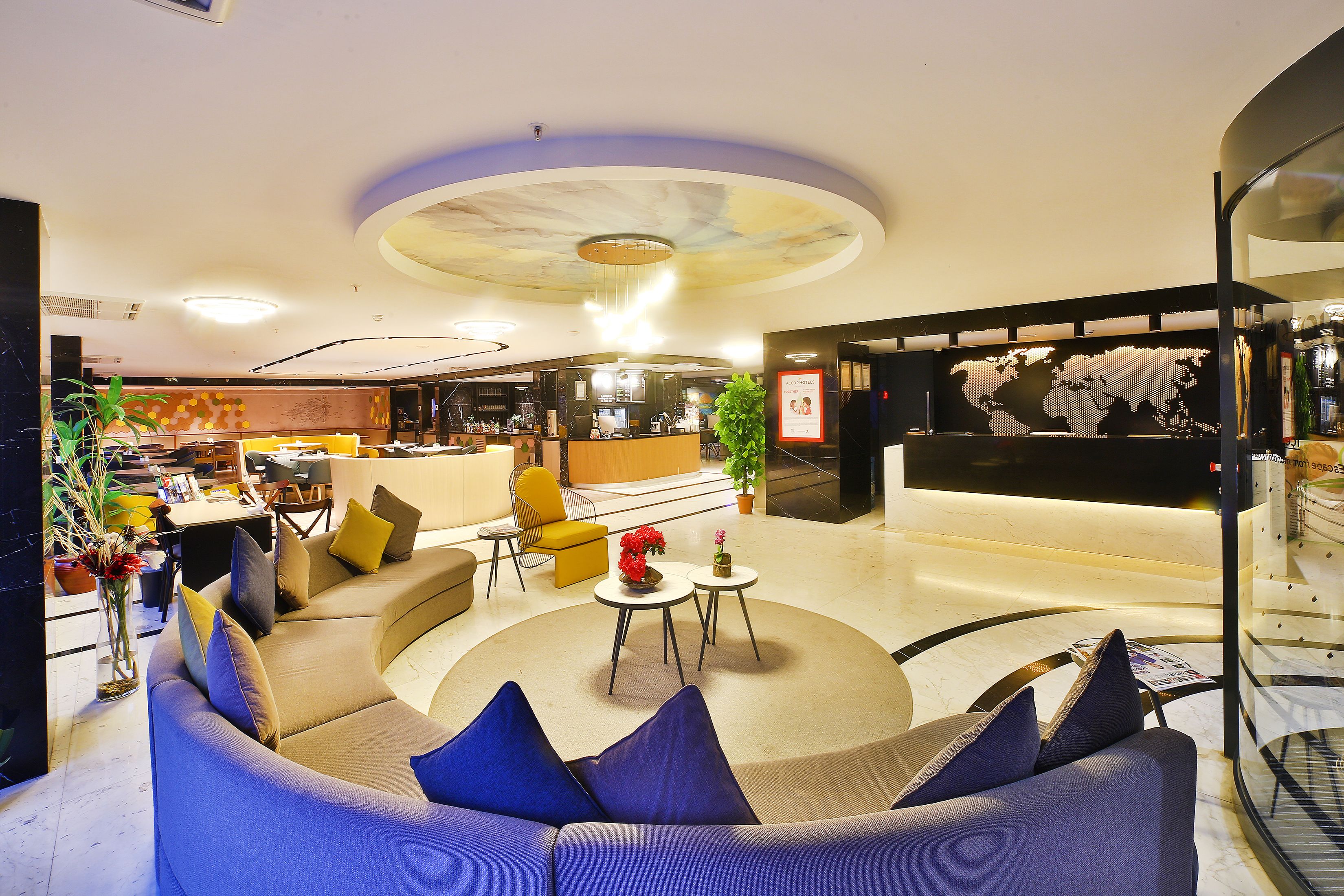 A modern lobby with a curved seating area, a reception desk, and a world map display.