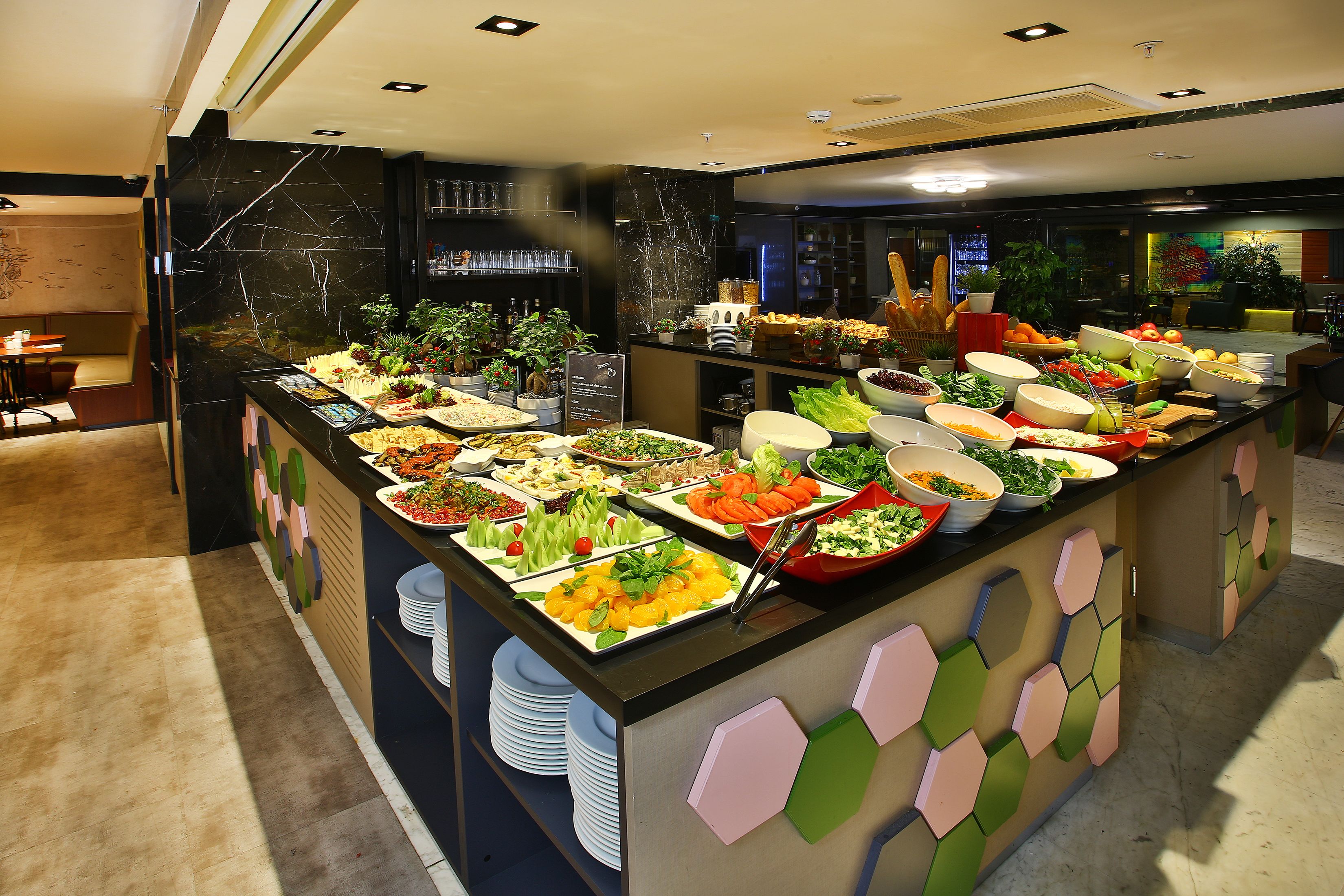 A buffet with various food items and a seating area with chairs and a table.