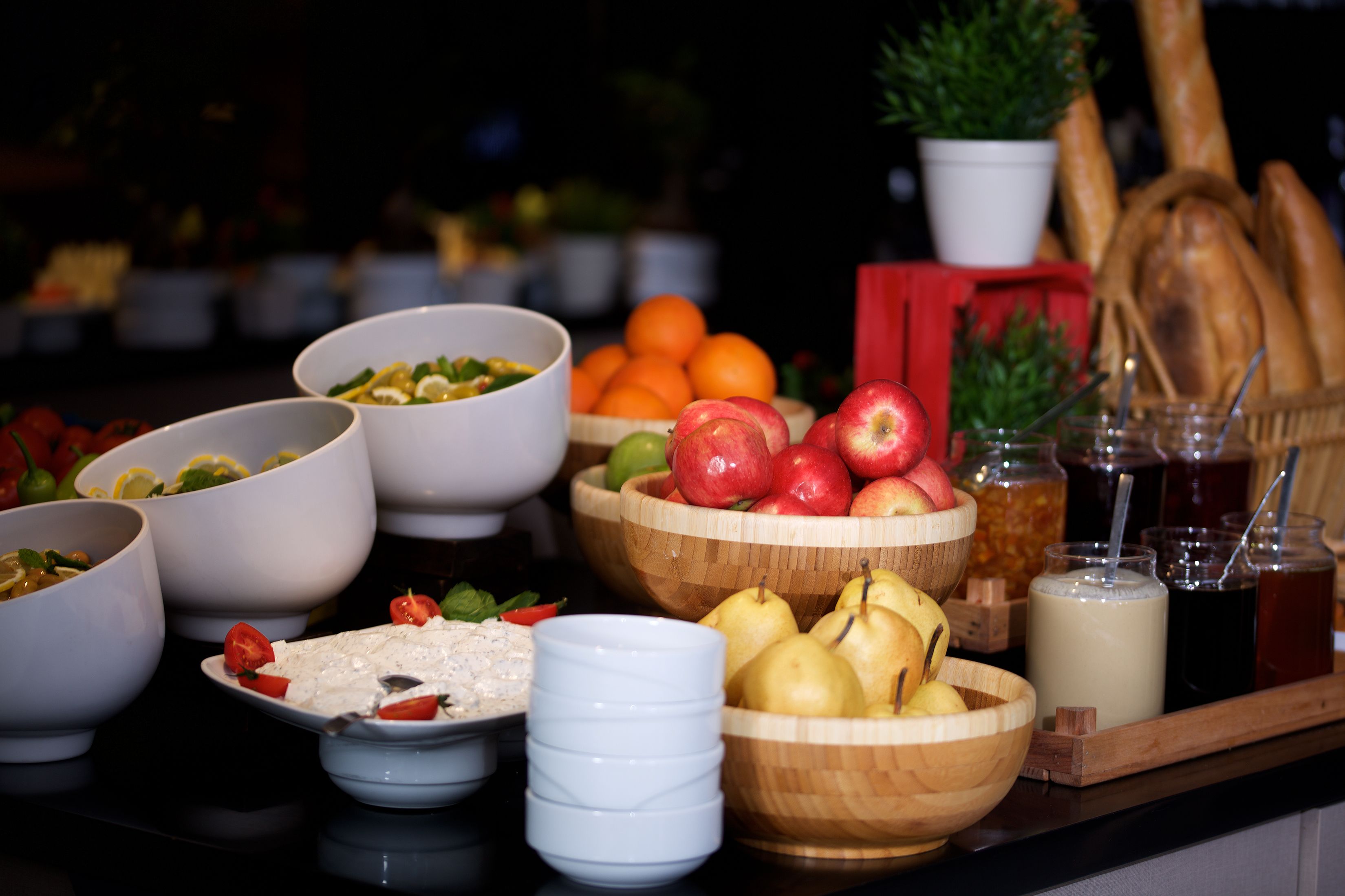 Une table de buffet proposant une variété d’aliments, notamment des fruits, des légumes et des boissons.