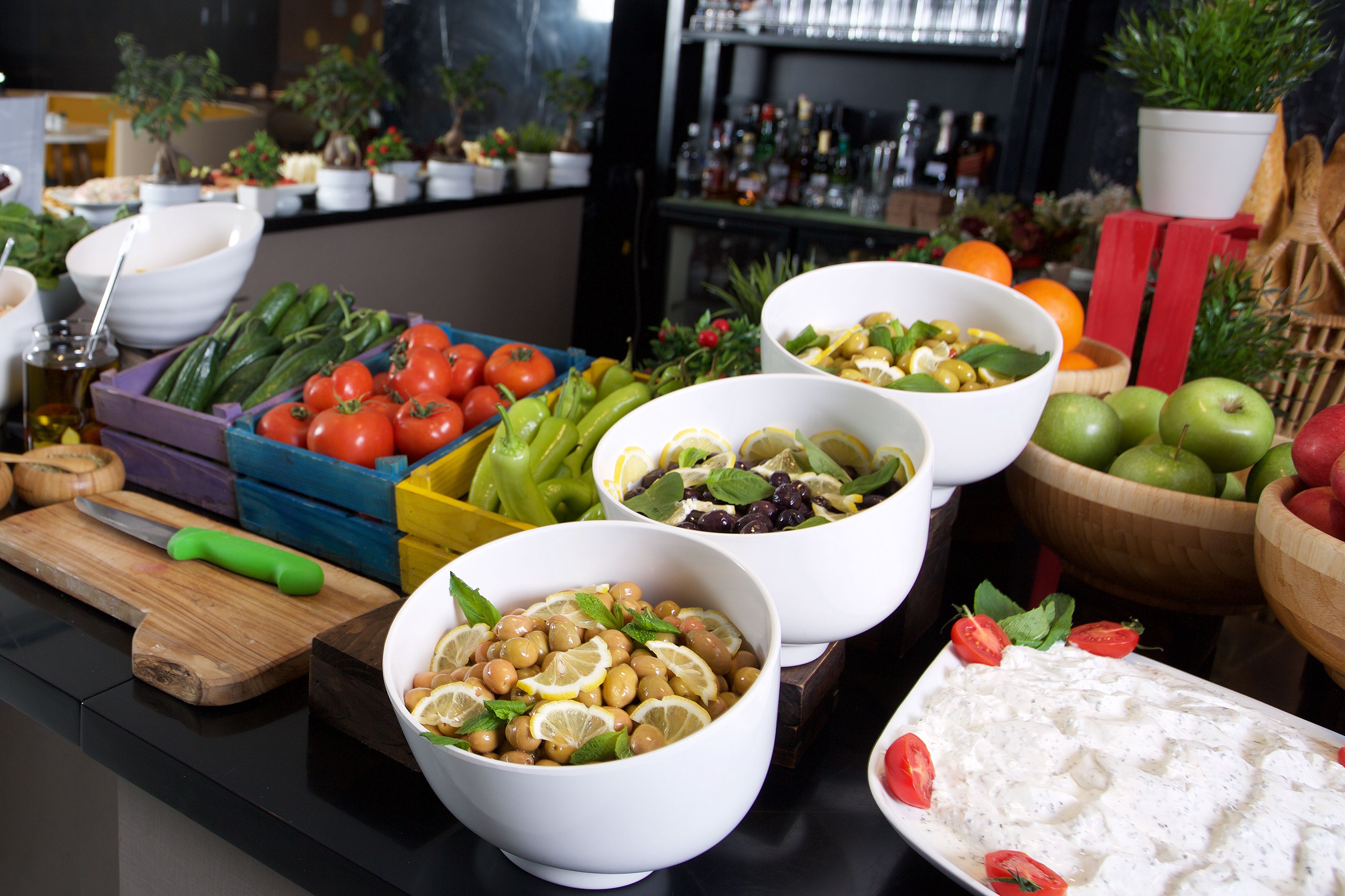 A buffet table with various food items and bowls.