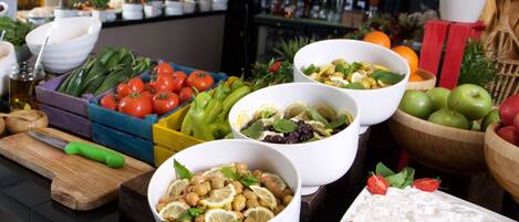 A buffet table with various food items and bowls.