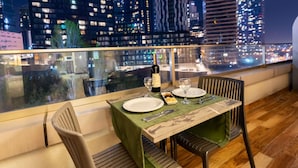 A dining table set for two with a cityscape view, a bottle of wine, and a glass. - ibis Styles Istanbul Bomonti (Istanbul)