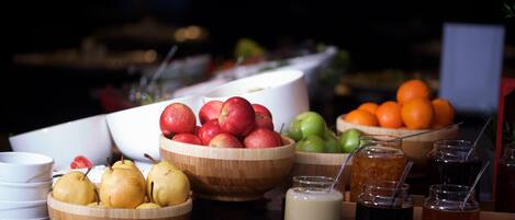 Un bufé con frutas y bebidas variadas.