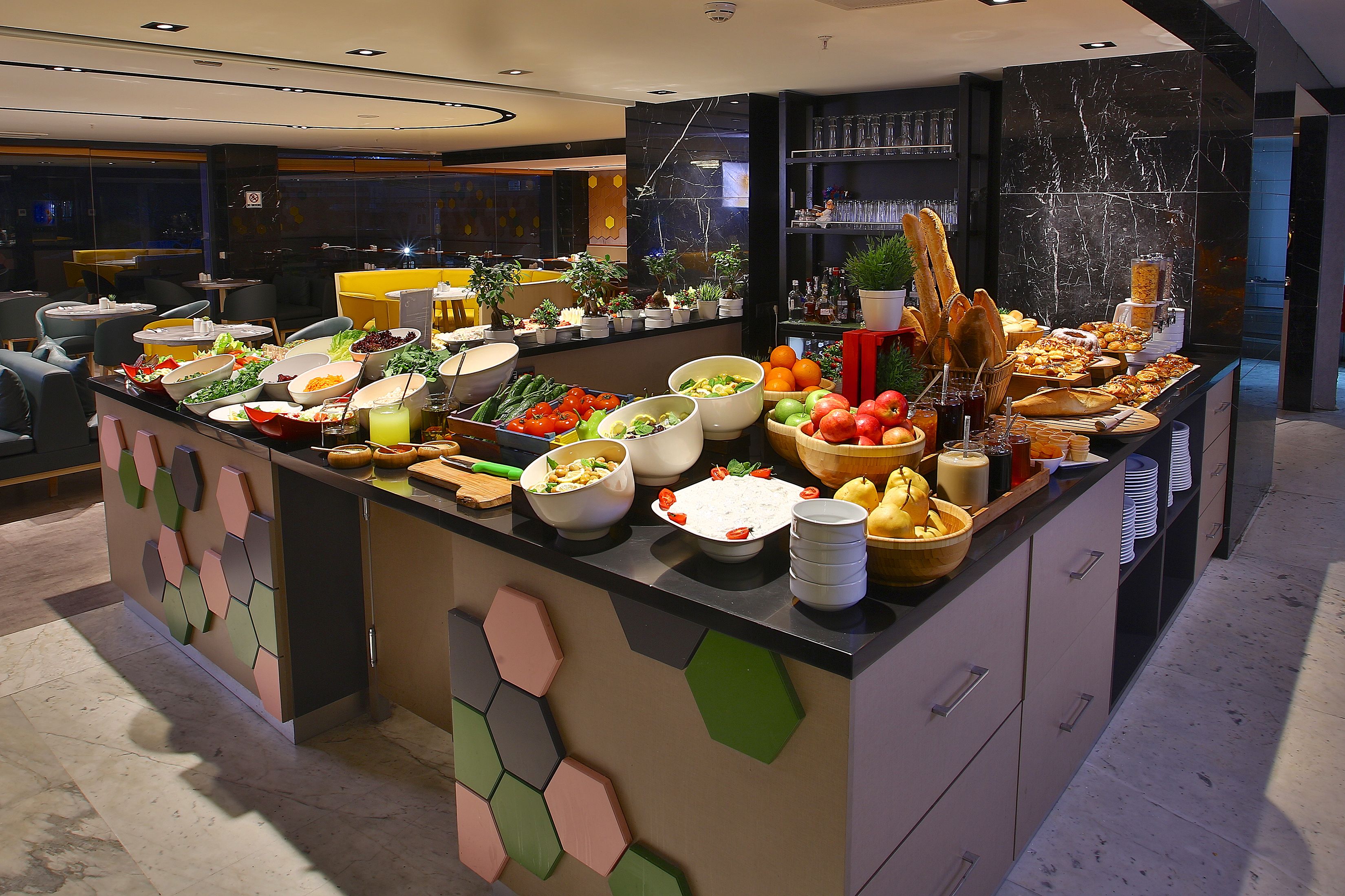 A buffet with various food items and a modern interior design.