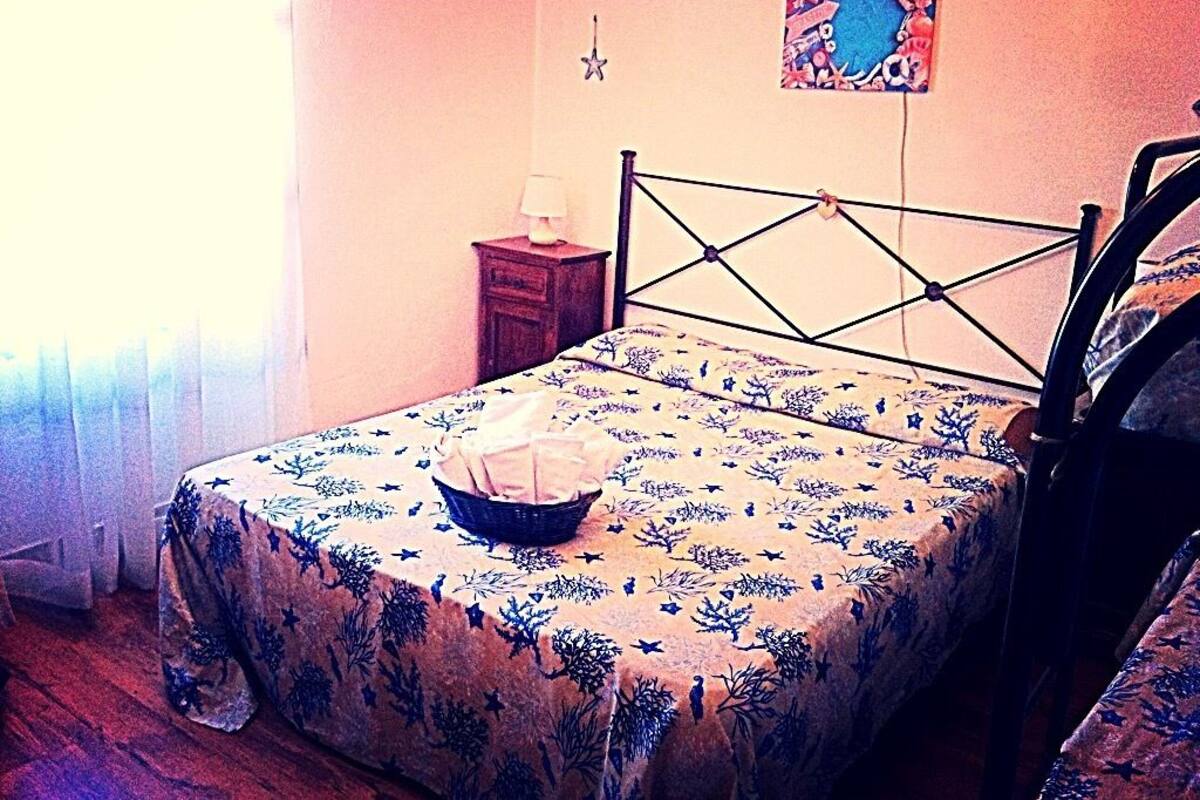 Ein Schlafzimmer mit Bett, Nachttisch, Lampe und Wanddekoration.