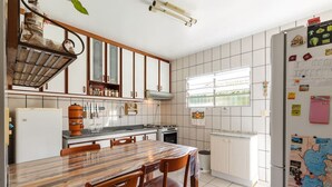 Una cocina con armarios blancos, una mesa de comedor de madera y un mapa en el refrigerador.