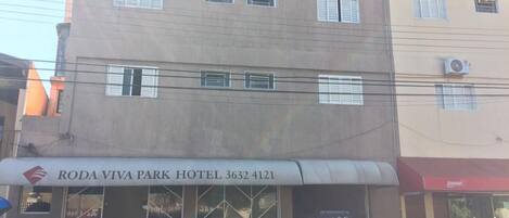A building with a sign for Roda Viva Park Hotel, featuring a car parked in front.