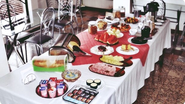 A breakfast buffet with various food items and condiments on a table. - Roda Viva Park Hotel (Jales)