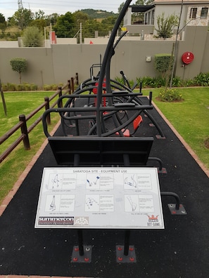 Outdoor exercise equipment with instructional signage. - Nova Luxury Suites Saratoga 112 (Sandton)